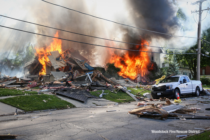 House burning with a Nicor utility pickup truck at the curb after the home was leveled by an apparent natural gas explosion on Monday, October 9, 2023 (SOURCE: Woodstock Fire/Rescue District).